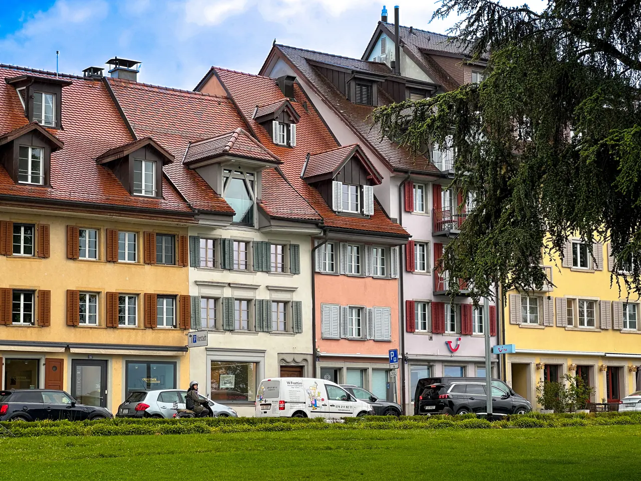 Colorful old houses lining the edge of a lawn