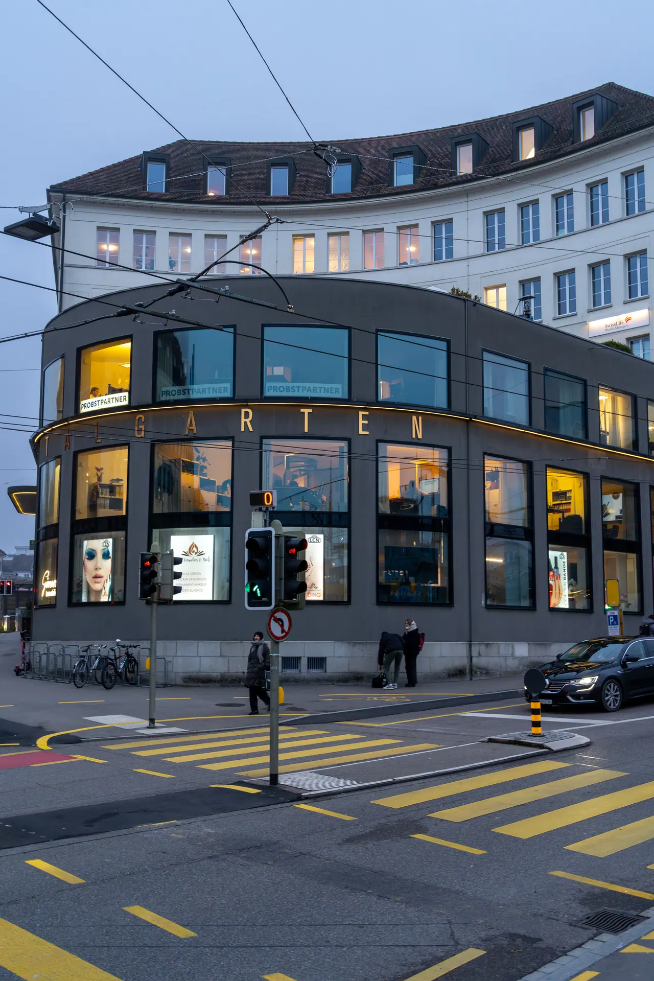 A rounded corner facade illuminated at dusk