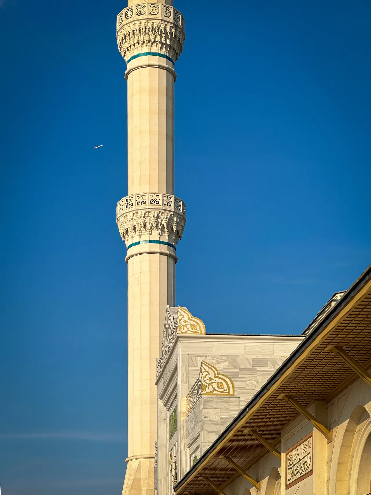 A minaret drawn sharply against a cloudless sky